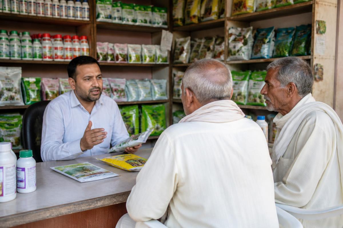 Agri-input dealer speaking with farmers at the counter